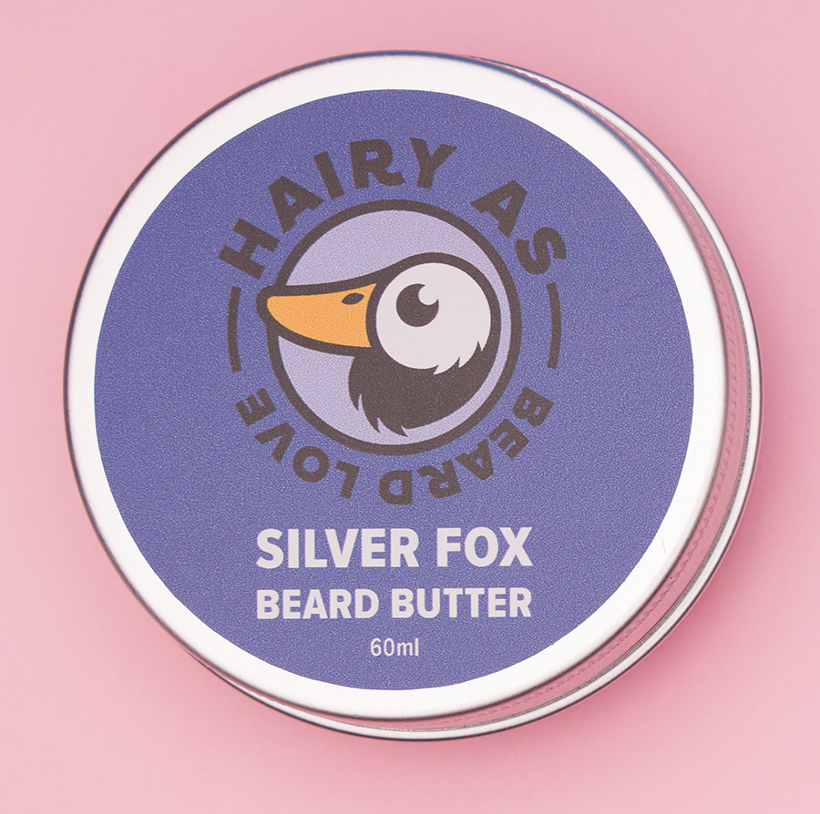 Tin of Silver Fox Beard Butter on pink background showcasing its elegant packaging and premium, smooth texture designed for sophisticated beard grooming and nourishment.